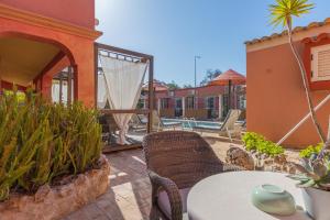 a patio with a table and chairs and a pool at Villas D. Dinis - Charming Residence (adults only) in Lagos