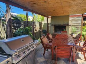a patio with a grill and a table with chairs at Dai Heka Guest House in Strand