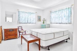 1 dormitorio con cama, escritorio y silla en Cozy cottage for longer stays!, en Vero Beach
