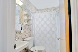 uma casa de banho com um WC, um lavatório e um chuveiro em Cozy cottage for longer stays! em Vero Beach