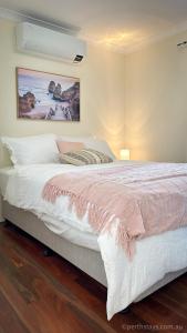 a bedroom with a large bed with a pink blanket at Fremantle High Street Retreat in Fremantle