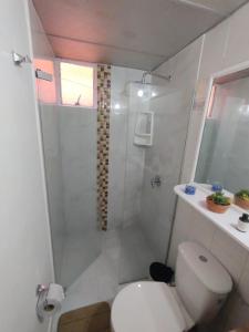 biała łazienka z prysznicem i toaletą w obiekcie Habitación ITCI – Terminal Salitre w mieście Bogota