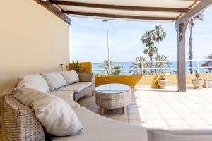 sala de estar con sofá y vistas al océano en Comodidad en primera linea de playa, en Benalmádena