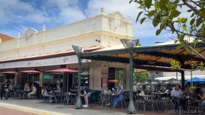 a group of people sitting at tables outside of a building at Fremantle High Street Retreat in Fremantle