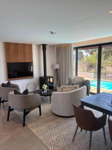 sala de estar con sofás, mesas y TV en Vergenoegd Löw Boutique Hotel & Spa, en Ciudad del Cabo