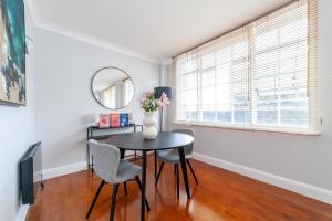 a dining room with a table and chairs and a mirror at Cosy Apartment Steps From London Eye in London