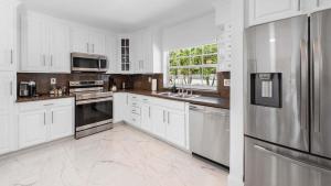 a kitchen with white cabinets and stainless steel appliances at Villa Seabreeze in Fort Lauderdale