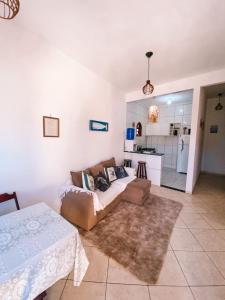 ein Wohnzimmer mit einem Sofa und einer Küche in der Unterkunft Casa em arraial do cabo / Monte Alto in Arraial do Cabo