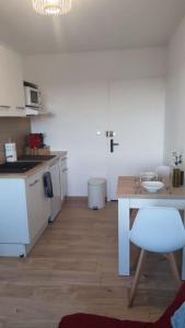 uma cozinha com uma mesa e uma cadeira num quarto em Charmant T1Bis rénové avec goût em Rodez