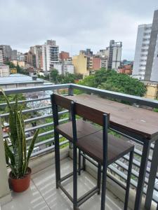 a wooden table and a chair on a balcony at Monoambiente Confortable Tucuman in San Miguel de Tucumán