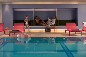 un groupe de personnes assises autour d'une piscine dans l'établissement Aalernhüs hotel & spa, à Sankt Peter-Ording