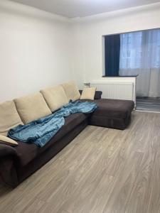 een woonkamer met een bruine bank en een houten vloer bij TwinsHause in Craiova