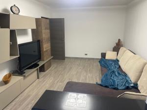 een woonkamer met een bank en een tv bij TwinsHause in Craiova