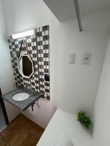 a bathroom with a sink and a mirror at Pousada Mangai in João Pessoa