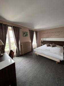 um quarto com uma cama e uma grande janela em LOGIS Hôtel & Restaurant - Les Bords de Seine em La Roche-Guyon