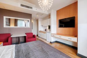 Cet appartement comprend une chambre avec un lit, une télévision et une cuisine. dans l'établissement Lux Residence w Balcony 1 min to Metro in Merter, à Istanbul