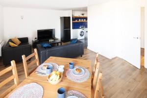 a living room with a wooden table and a couch at Modern and spacious 2-BR, 2-BA retreat near Tower Bridge in London
