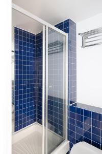 a bathroom with a shower with blue tiles at Modern and spacious 2-BR, 2-BA retreat near Tower Bridge in London