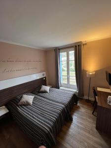 a bedroom with two beds and a window at LOGIS Hôtel & Restaurant - Les Bords de Seine in La Roche-Guyon
