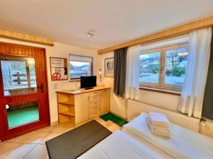 a living room with a desk and a tv in it at Haus Kogler in Aich