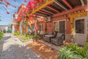 a patio of a house with a chair and flowers at Villas D. Dinis - Charming Residence (adults only) in Lagos