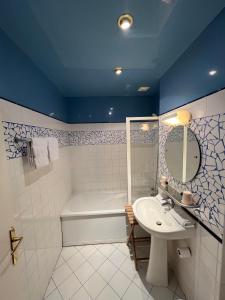 y baño con lavabo y bañera. en LOGIS Hôtel & Restaurant - Les Bords de Seine en La Roche-Guyon