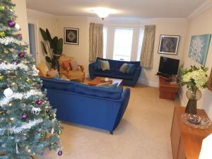 a living room with a christmas tree and a blue couch at Sandy Gem - Viking Bay Getaway in Kent