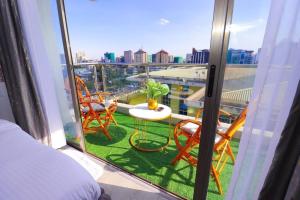 a room with a balcony with chairs and a table at The Gold Park 2 bedroom Kilimani in Nairobi