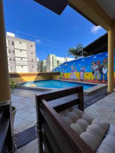 a swimming pool with a mural on the side of a building at Pousada Mangai in João Pessoa
