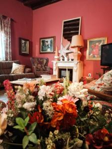 a living room filled with flowers in front of a fireplace at Casa rural de la Abuela in Cadreita