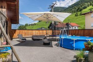 a patio with an umbrella and a pool at s'Peaters in Imsterberg