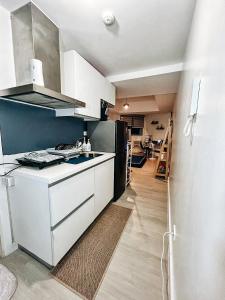 a kitchen with white cabinets and a black refrigerator at KPlace Staycation at Azure North in San Fernando