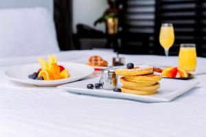 a plate of pancakes and fruit on a table at Tideline Palm Beach Ocean Resort and Spa in Palm Beach