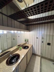 a bathroom with two sinks and two mirrors at Pousada Mangai in João Pessoa