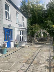 uma casa com uma porta azul e um passadiço de pedra em Carefully renovated traditional Irish Town-house em Lisdoonvarna