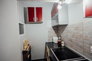 a kitchen with white cabinets and a black sink at MM apartman in Valjevo +4 photos