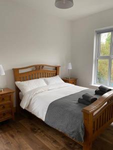 um quarto com uma cama com lençóis brancos e uma janela em Carefully renovated traditional Irish Town-house em Lisdoonvarna