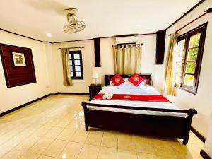 a bedroom with a bed with red pillows on it at Vieng Savanh II Hotel in Luang Prabang