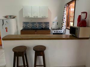een keuken met twee krukken aan een aanrecht bij Villa Objetivo Trancoso in Trancoso