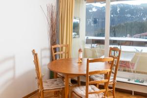 uma mesa e cadeiras num quarto com uma janela em Residence Clos Soleil 22a em Leysin