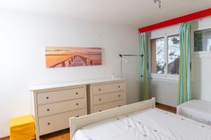 - une chambre avec un lit, une commode et une fenêtre dans l'établissement Residence Clos Soleil 22a, à Leysin