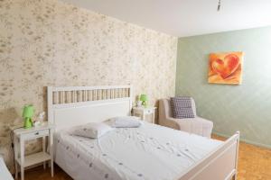 - une chambre avec un lit blanc et une chaise dans l'établissement Residence Clos Soleil 22a, à Leysin