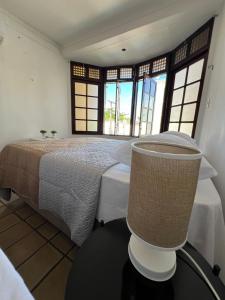 a bedroom with a bed in a room with windows at Pousada Mangai in João Pessoa