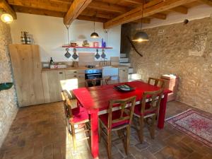 cocina con mesa de comedor roja y sillas en Podere Cereo, en Villaga