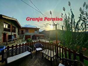 a house with benches and a fence with the words grandma panama at Hotel Granja Paraíso, Oasis Rural & Bienestar in Cangas de Onís