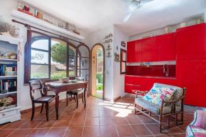 a kitchen with red cabinets and a table and chairs at Le Tortore - Villetta vista mare in Magazzini