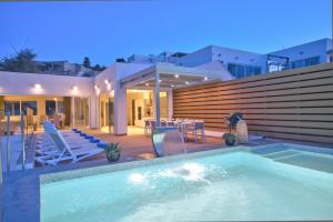 a swimming pool in front of a house at Maltese Luxury Villas - Sunset Infinity Pools, Indoor Heated Pools and More! in Mellieħa