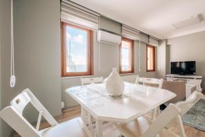 una sala da pranzo bianca con tavolo e sedie bianchi di Duplex Flat Near Bilgi University and Golden Horn a Istanbul