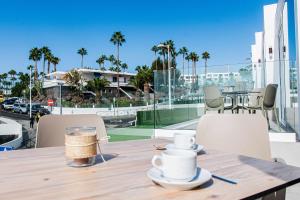 un balcón con una mesa de madera con tazas y sillas. en Amor a mar seahorse, en Puerto del Carmen 8 fotos más