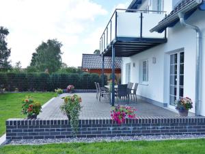 a patio with a table and chairs in a yard at Feldstrasse 3 b in Zempin